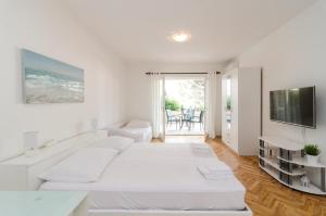 Un dormitorio blanco con una gran cama blanca y una ventana en House Apartments Ariva, en Dubrovnik