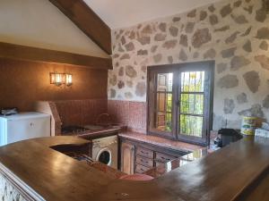 a kitchen with a counter and a stove and a window at Joli Chalet dans une ferme Pour familles exclusivement près ifrane in Azrou
