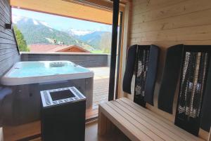 a sauna with a tub and a view of a mountain at Kranzmuehle - Ankommen am Achensee in Achenkirch