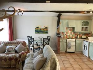 a living room with a couch and a kitchen at Meal House in Narborough