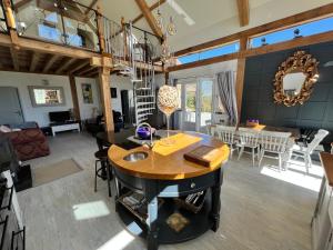 een keuken en een woonkamer met een houten plafond bij Maison De Lavende in Bessines-sur-Gartempe