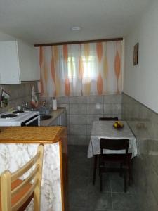 cocina con mesa, mesa y sillas en Apartman Jovanovic-Rudnik en Rudnik