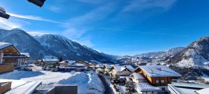 a village covered in snow with mountains in the background at Ski- & Sonnenresort Alpendorf by AlpenTravel in Sankt Johann im Pongau