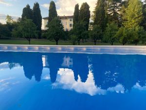 ein Pool mit Bäumen und ein Gebäude im Hintergrund in der Unterkunft Appartamento lusso con piscina tra Milano e Como in Costa Masnaga