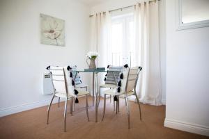 comedor con mesa de cristal y sillas en Superb Apartment in Stratford upon Avon with Free Parking & Wi-Fi, en Stratford-upon-Avon