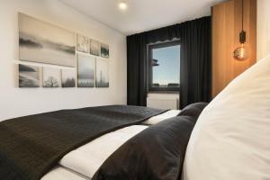 1 dormitorio con 2 camas y ventana en Place 4you en Grafenau