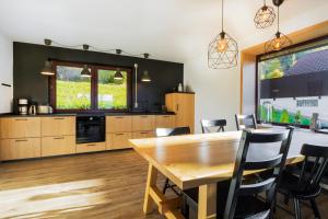 a kitchen with a wooden table and chairs at Place 4you in Grafenau