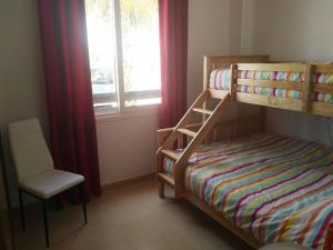 1 dormitorio con litera, silla y ventana en Casa fama en Murcia
