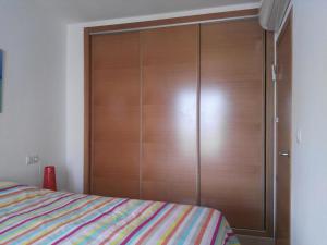 um armário de madeira num quarto com uma cama em Casa fama em Múrcia