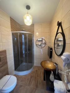 uma casa de banho com um chuveiro, um WC e um lavatório. em Bursztynowa em Łuków