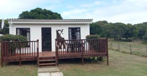 un porche con una estatua de una jirafa. en Faithlands Self-Catering Cottages, en Port Elizabeth