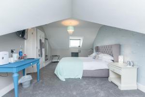 um quarto com uma cama e uma secretária azul em Seaview B&B em Harwich