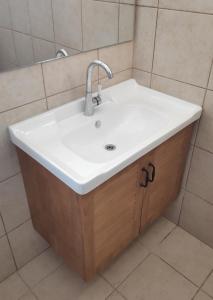een badkamer met een witte wastafel en een spiegel bij אחת ויחידה - One & Only in Ma'alot-Tarshiha