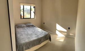 Schlafzimmer mit einem Bett und einem Fenster in der Unterkunft Casa de los lagos in Rivera