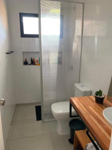 a bathroom with a shower and a toilet and a sink at Casa de los lagos in Rivera