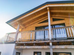 a wooden house with a balcony on top of it at Chalet Charivari Inzell, Inzell in Inzell