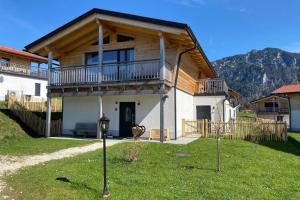a house with a balcony on top of a yard at Chalet Charivari Inzell, Inzell in Inzell