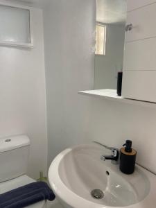 a white bathroom with a sink and a toilet at Elenitas Town house with Balcony and Sea View in Mikonos