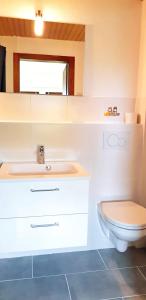 a bathroom with a white sink and a toilet at Strandhafer in Hörnum