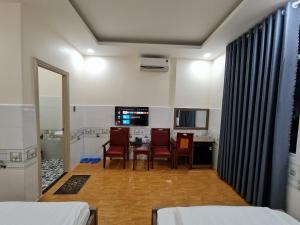 a room with a table and chairs and a kitchen at Khách Sạn Cốc Cốc in Rạch Giá