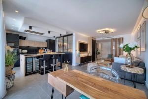 a kitchen and living room with a table in a room at Cannes Luxury Rental - Stunning sea front apartment in Villeneuve-Loubet