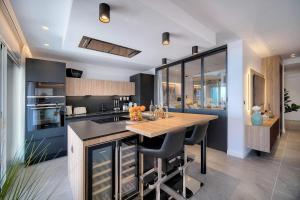 a kitchen with a wooden table and a counter at Cannes Luxury Rental - Stunning sea front apartment in Villeneuve-Loubet