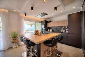 a kitchen with a wooden table and black cabinets at Cannes Luxury Rental - Stunning sea front apartment in Villeneuve-Loubet +14 photos