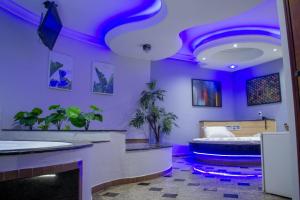 a purple room with a bed and plants in it at Motel Copacabana in Ribeirão Preto