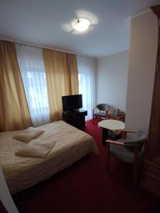 a hotel room with a bed and a television at Delfin in Mielno