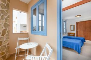 a room with a bed and a table and chairs at Hostal Marina in Cala Ratjada