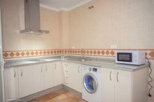 a kitchen with a washing machine and a microwave at 2 bedrooms appartement with wifi at Penaflor in Peñaflor