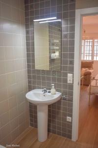 een badkamer met een wastafel en een spiegel bij 2 bedrooms appartement with wifi at Penaflor in Peñaflor