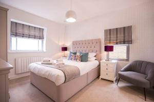 een slaapkamer met een groot bed en een stoel bij Urban Living's ~ King Edward Luxury Apartments in the heart of Windsor in Windsor