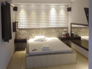 a bedroom with a white bed and a window at Motel Copacabana in Ribeirão Preto