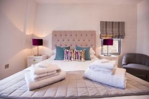1 dormitorio con 1 cama grande y toallas. en Urban Living's ~ King Edward Luxury Apartments in the heart of Windsor en Windsor
