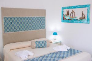 a bedroom with a bed and a painting on the wall at Hotel Canne al Vento in Santa Teresa Gallura