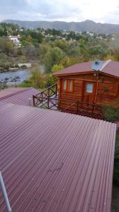 una cabina di legno con un grande tetto di metallo di Cabañas La Escondida Casa De campo a San Antonio de Arredondo