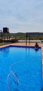 a large blue swimming pool with a hose at Cabañas La Escondida Casa De campo in San Antonio de Arredondo +12 photos