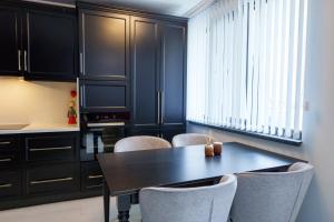 comedor con mesa negra y sillas en Loft Apartment with a great view of Ardino, en Ardino