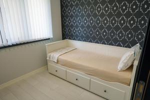 a small bed in a bedroom with a wall at Cozy Apartment with a great view of Ardino in Ardino