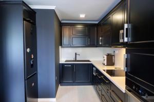 - une cuisine avec des placards noirs et un évier dans l'établissement Loft Apartment with a great view of Ardino, à Ardino