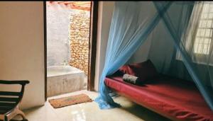 Zimmer mit einem roten Bett in einem Zimmer mit Badewanne in der Unterkunft Malabar home stay in Jaffna
