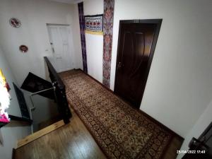 Cette chambre est dotée d'un escalier avec une porte et un tapis. dans l'établissement Naqqosh, à Khiva