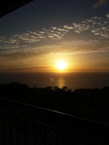a sunset over the ocean with the sun in the sky at Noemie Studios in Athanion