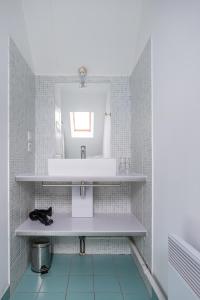 ein Bad mit einem Waschbecken und einem Spiegel in der Unterkunft Gîte Le Bisquin in Cancale