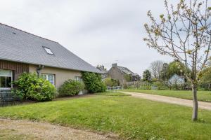 ein Haus mit einem Baum und einer unbefestigten Straße in der Unterkunft Gîte Le Bisquin in Cancale