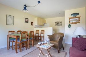 ein Wohnzimmer mit einem Tisch und Stühlen in der Unterkunft Gîte Le Bisquin in Cancale