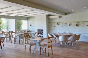 a dining room with tables and chairs and a fireplace at Le Quartier Francais in Franschhoek