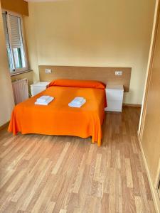 1 dormitorio con 1 cama con manta naranja en Apartment Lecer 5 - 1st floor, en Porta