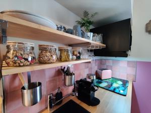 una cocina con una barra con tarros de comida en LA BULLE ROMANTIQUE, Suite avec jacuzzi privatif, 